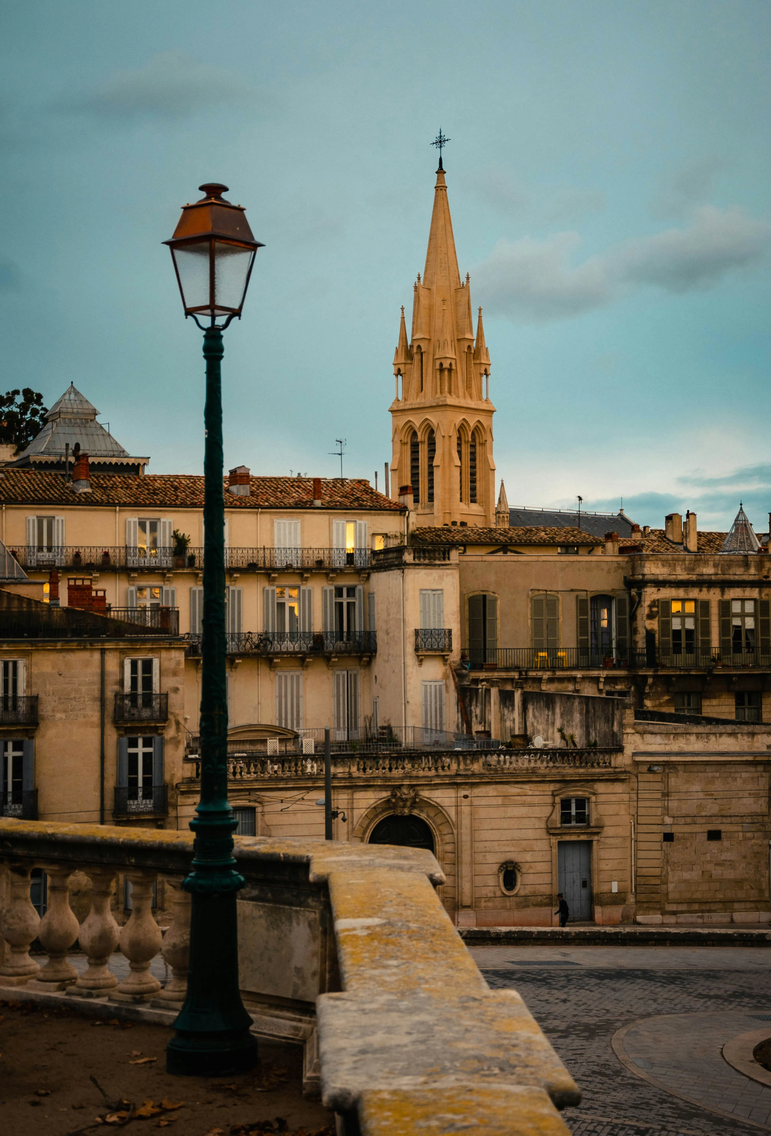 Façade en pierre claire et clocher de Montpellier éclairés à l'heure dorée