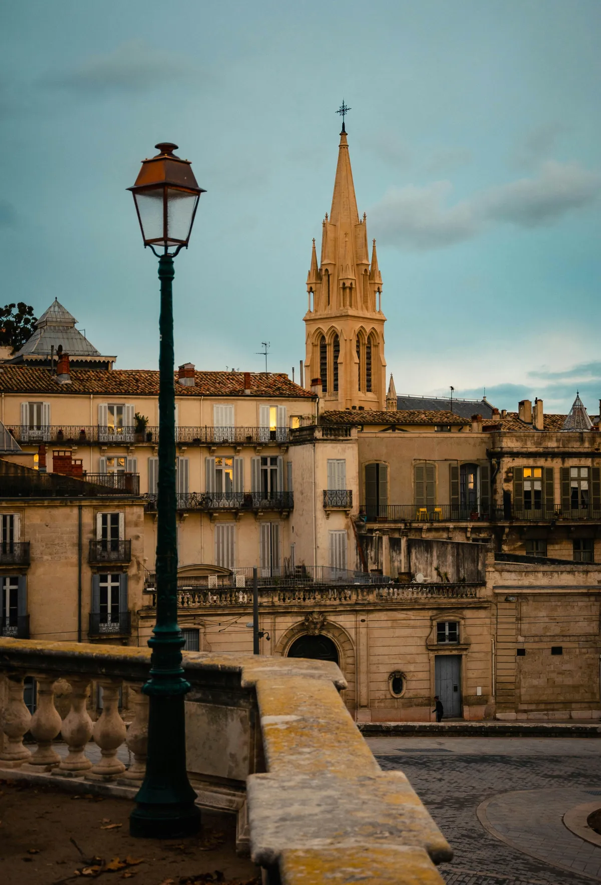Façade en pierre claire et clocher de Montpellier éclairés à l'heure dorée