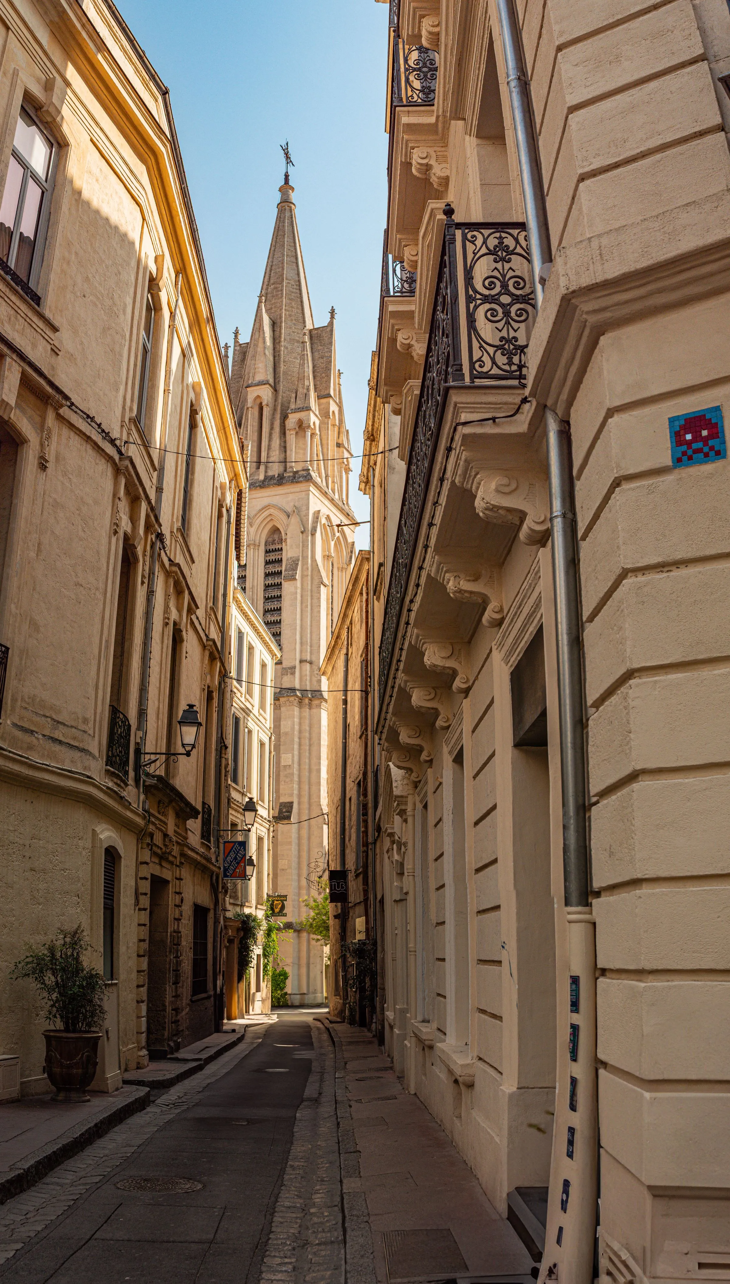 Ruelle pavée de l'Écusson, pierre dorée, clocher Sainte-Anne en fond