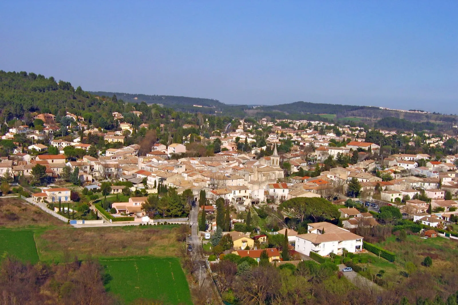 Toits de tuiles et clocher du village de Grabels, adossé aux collines de garrigue
