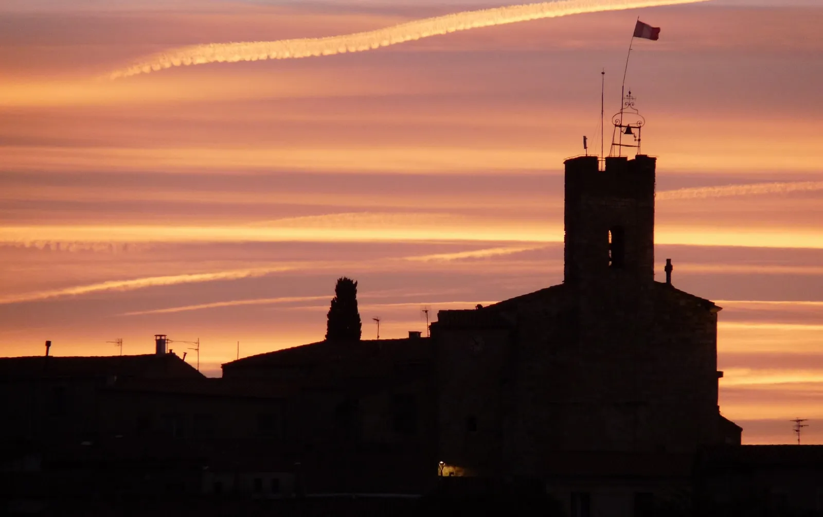 Clocher fortifié et toits du vieux village perché de Montferrier-sur-Lez au coucher du soleil